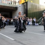 Mujeres con trajes de sevillana negro y topos blancos