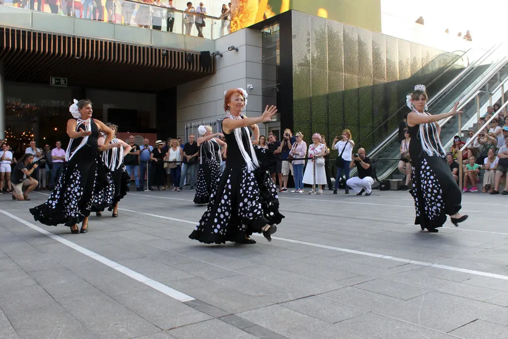 Mujeres con trajes de sevillana negro y topos blancos