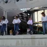 Jóvenes de la asociación vestidos de vaquero haciendo una actuación