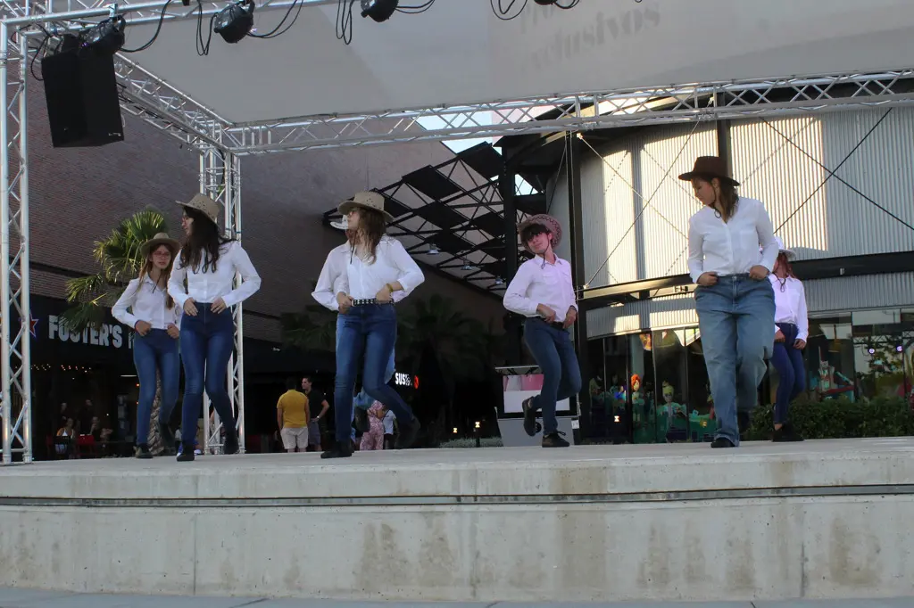 Jóvenes de la asociación vestidos de vaquero haciendo una actuación