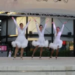 3 mujeres bailando vestidas de blanco