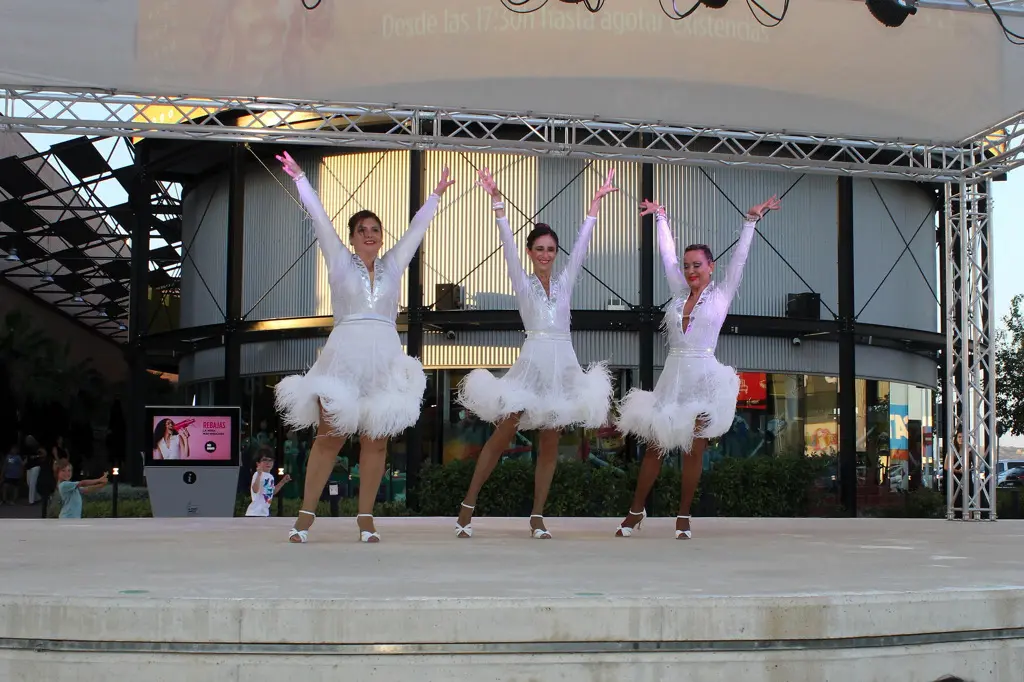 3 mujeres bailando vestidas de blanco
