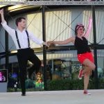 Pareja bailando delante de personas